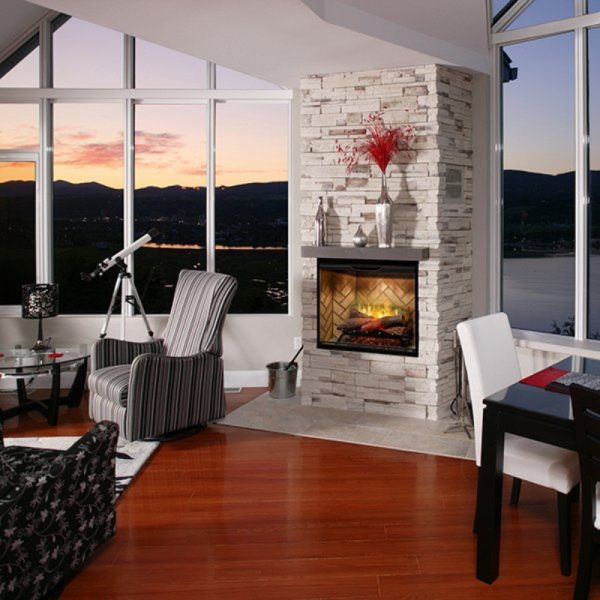 Cozy living room featuring a modern stone fireplace, large windows with a sunset view, a telescope, and stylish furniture.