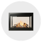 Modern glass-front fireplace with flickering flames and decorative stones.